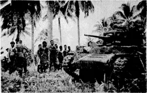 A Valentine lank, used by New Zealand troops in the attack on Nissan Island, is looked over by natives after the action. (Evening Post, 18 March 1944)