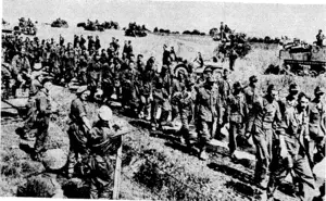l\ow a famihar scene in France. German soldiers on a road behind the firing line are marched oft to a prisoners-of-war cage. In the background is a column of British armour. (Evening Post, 25 October 1944)
