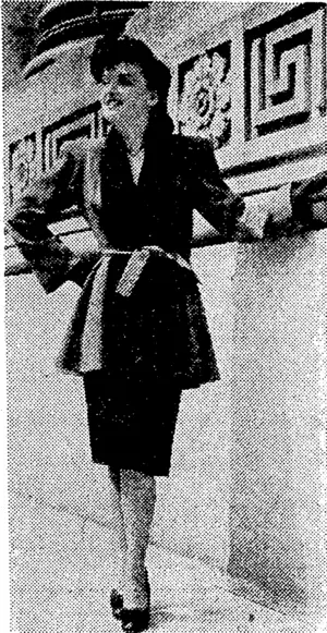 A plain, red tunic coal irimmed with black Persian tuxedo front and having a soft self bell. It is worn with a slim skirt of black wool. (Evening Post, 04 November 1944)