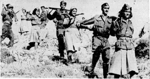 Greek Partisans passing through hilly country near Athens. (Evening Post, 09 December 1944)