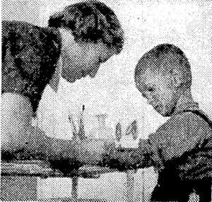 A British Red Cross helper in Yugoslavia attending to an injured boy in a children's clinic. The boy had been wounded by a mine. (Evening Post, 03 August 1945)