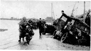 The Germans in their retreat thro ugh Holland broke Dutch dams and dykes, so that great stretches of country are now under water. Allied vehicles are here seen ditched through running off the road hidden by the flood. (Evening Post, 23 January 1945)