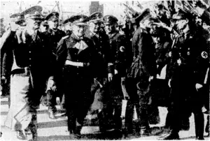 Herr Hitler, whose birthday ivas celebrated in Germany yesterday as a national holiday, is shown arriving at Wilhelmshaven on April 3 to launch the battleship Von Tirpitz. Amazing precautions were taken to ensure his safety, special guards facing the crowd, as seen in the photograph. (Evening Post, 21 April 1939)
