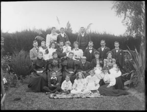 Family group portrait, members unidentified, in a garden, location unidentified