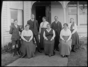 Unidentified family group, outside entrance to a wooden house, probably Christchurch district