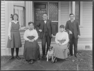 Unidentified family group with dog, outside entrance to house, probably Christchurch district