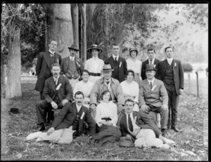 Unidentified group portrait of men and women under some trees, wearing ribbons with assigned functions on them, such as starter, committee, judge, probably Christchurch region