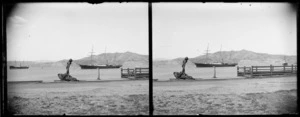 View from quay [of Wellington Harbour?], including a large anchor in the foreground, and steam ship Hinemoa at sea