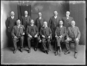 Studio portrait of a unidentified group of ten well dressed older men [Hibernian Australasian Catholics Benefit Society members?], front centre male with long 'mutton chop' sideburns, Christchurch