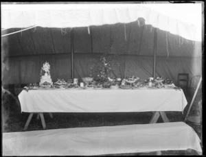 Trestle table with wedding cake, food and flowers within a tent, [Sumner?], Christchurch
