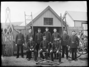 Unidentified group portrait of the Sydenham Fire Brigade, in dress uniforms and caps, outside their premises with fire fighting equipment, Christchurch