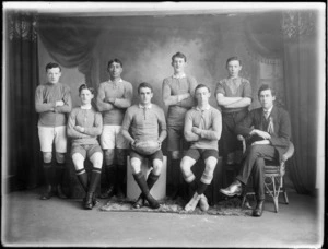 Studio portrait of the Woolston Rugby League Presidents young men's football team, unidentified players and coach wearing rosette, Christchurch
