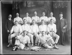 Studio portrait of unidentified men's cricket team and coaches, with players in white shirts and pants, with bats, balls and pads, Christchurch