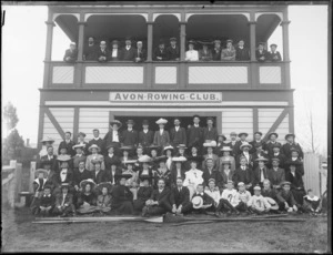 Avon Rowing Club building, with unidentified club members on balcony and on grass slope in front with oars, wearing an assortment of hat and caps, Christchurch