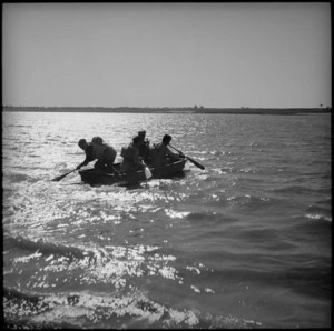 Assault party rowing across the water in assault boat, Egypt