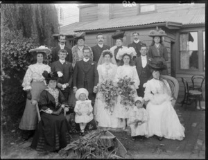Unidentified wedding group outside a house, showing bride and groom, bridesmaid, groomsman and family members, probably Christchurch district