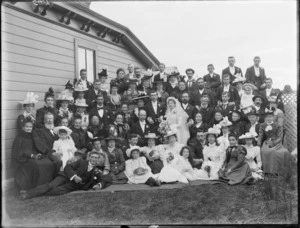 Large wedding group, showing unidentified men, women, and children, beside a house, possibly Christchurch district
