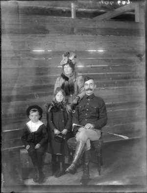 Family group, showing a man with a riding crop, a woman, boy and girl, in an interior with sarking, possibly Christchurch district