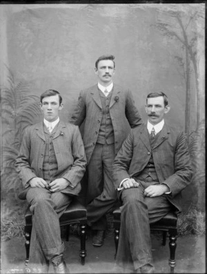 Formal portrait of three men, wearing day suits, with a studio backdrop, possibly Christchurch district
