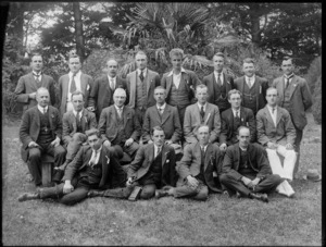 Group of unidentified men, some with a ribbon pinned to their lapel, in an outdoor location, possibly Christchurch district