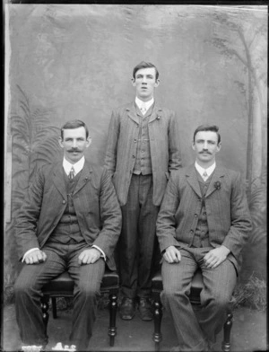 Formal portrait of three unidentified men, wearing day suits, with studio backdrop, possibly Christchurch district