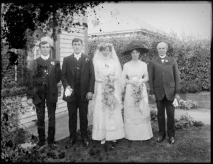Wedding group, showing three men and two women, all unidentified, standing on a lawn outside a wooden house, possibly Christchurch