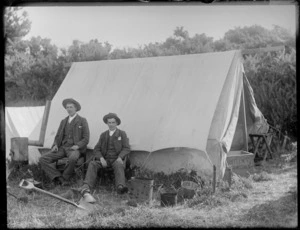 Two unidentified young men, sitting next to a tent, possibly Christchurch district