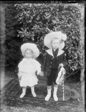 Two unidentified children, showing the little boy holding a cane, taken in the garden, possibly Christchurch district