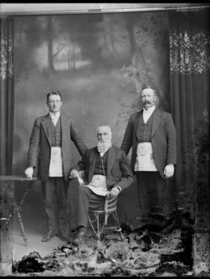 Studio portrait of three men wearing Freemason aprons, probably Christchurch region