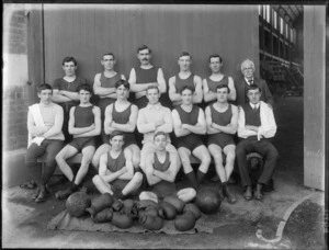 Unidentified members of a men's boxing team, taken outside the gym, showing boxing gloves in the front and a little black dog sitting in front of one of the men, possibly Christchurch district
