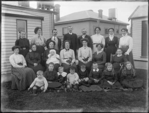 Members of unidentified family, three men, twelve women and nine children, in front of the house, possibly Christchurch district