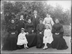 Members of an unidentified family in the garden, showing four women sitting with two girls, a boy, a man and a woman standing behind them, probably Christchurch district