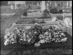 Flower covered grave, cemetery unidentified, possibly Christchurch district, showing other graves in the background