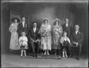 Wedding portrait of a unidentified bride and groom with the wedding party, including the flowergirl and the pageboy, in the studio, possibly Christchurch district