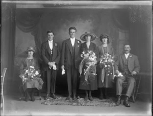 Wedding portrait of a unidentified bride and groom with the wedding party, in the studio, possibly Christchurch district