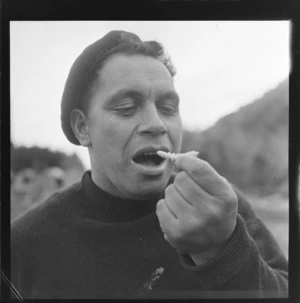 An unidentified Maori man eating huhu grubs