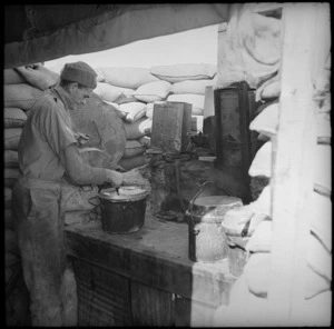 Cook working on an improvised stove, Egypt