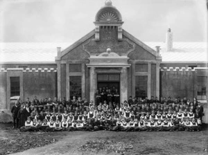 Group portrait of the students and teachers of Stratford Technical High School in front of the school buildings