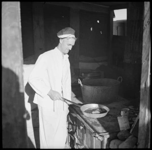 Cook at a stove in the Western Desert