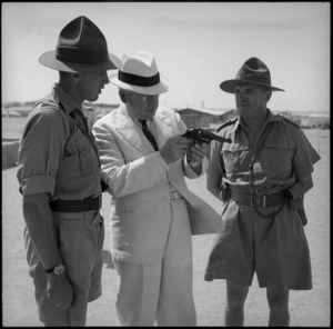 Prime Minister Peter Fraser examines a revolver at the NZ Infantry Training Depot, Maadi