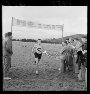 Unidentified runner crossing the finish line at the Harriers held at Trentham, Upper Hutt