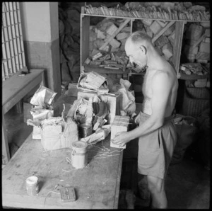 Sapper J A Reynolds rewrapping damaged parcels at the NZ Army Post Office in Cairo, Egypt