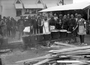 Men cooking over an an open fire after the Napier earthquake
