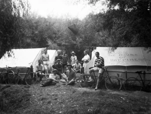 Camping scene showing a group of young men next to two tents