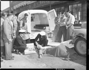 Staged photograph of Free Ambulance staff providing first aid - Photograph taken by W Wilson