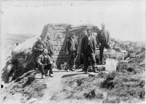 Chinese gold miners with Rev Alexander Don, outside a cob dwelling in Tuapeka, Otago
