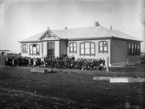 Group portrait of the students and teachers of Stratford Technical School outside the school building