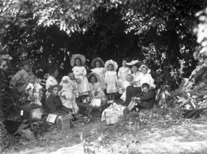 Two women and a group of children on a picnic