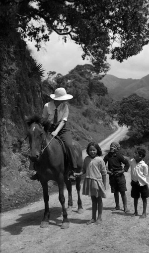 A woman on horseback and children