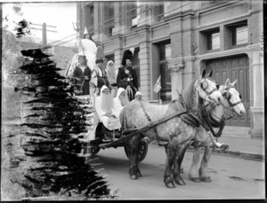 A float drawn by two horses with unidentified men in costume, on an unidentified street, possibly Christchurch district